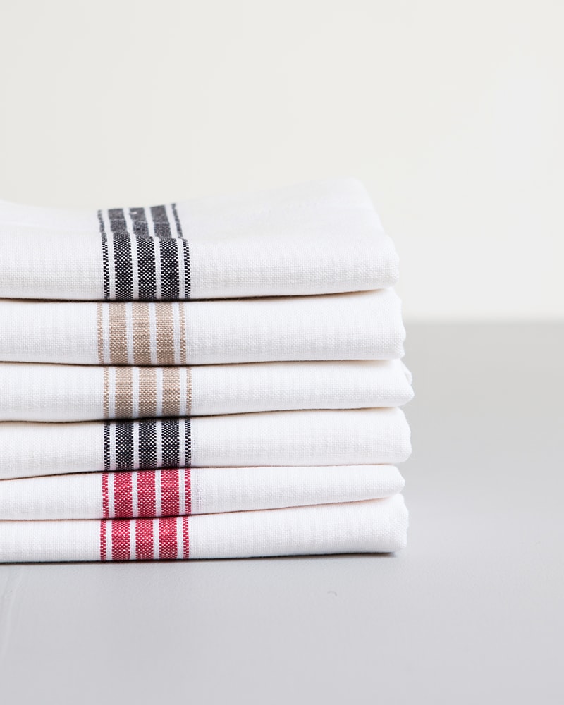 Mungo Provincial Stripe Napkins with various coloured stripes that run through the middles, inspired by french grain sacking material, pictured here in red, french navy and taupe