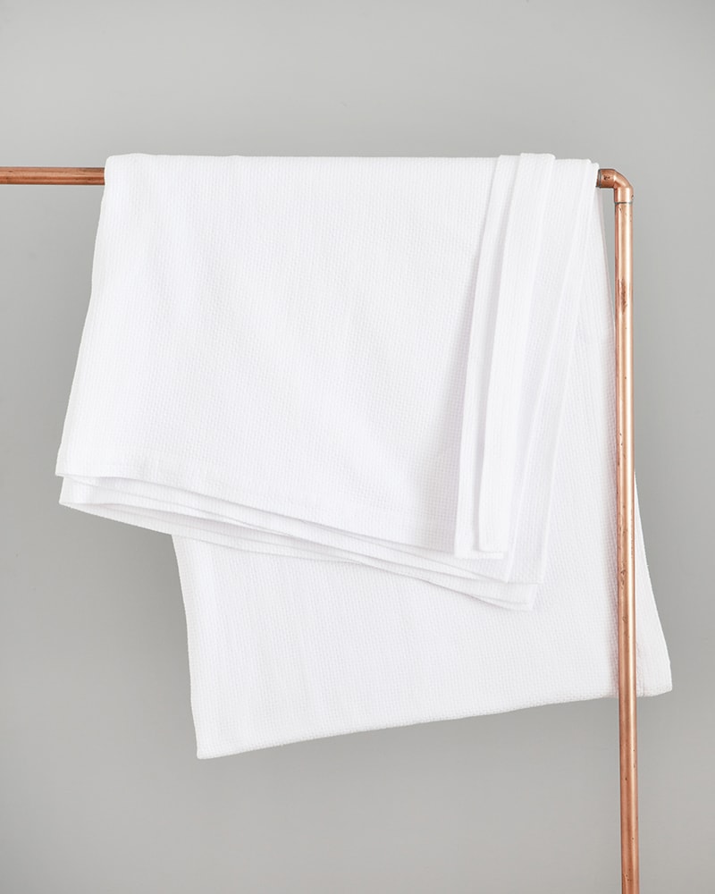 The Mungo Interlace Cotton Blanket Throw in White, a textile woven with all natural fibres at our mill in Plettenberg Bay, South Africa.